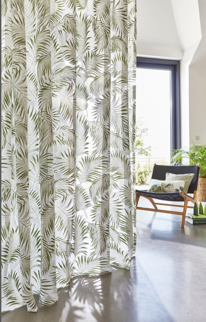Tropical leaf print curtains in a bright living room, adding a bold green pattern to a Hampshire home